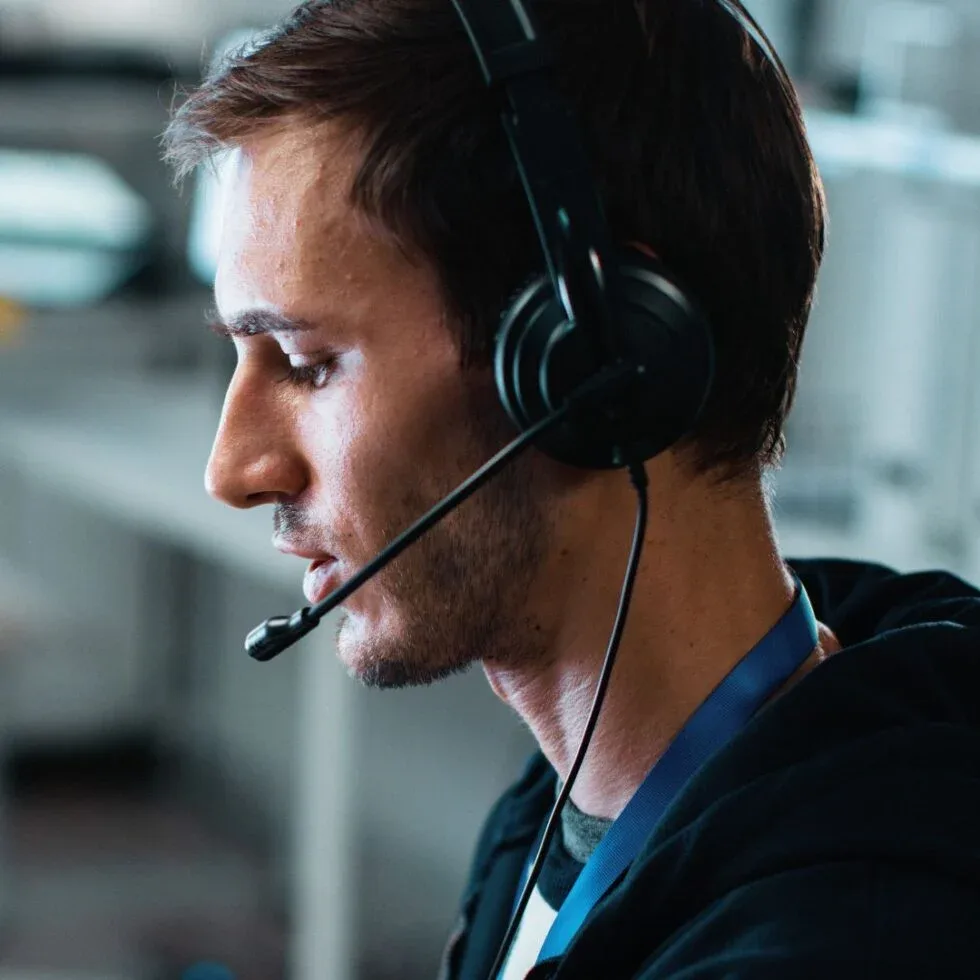 Tech Support Specialist helping a client over the phone with a headset on.