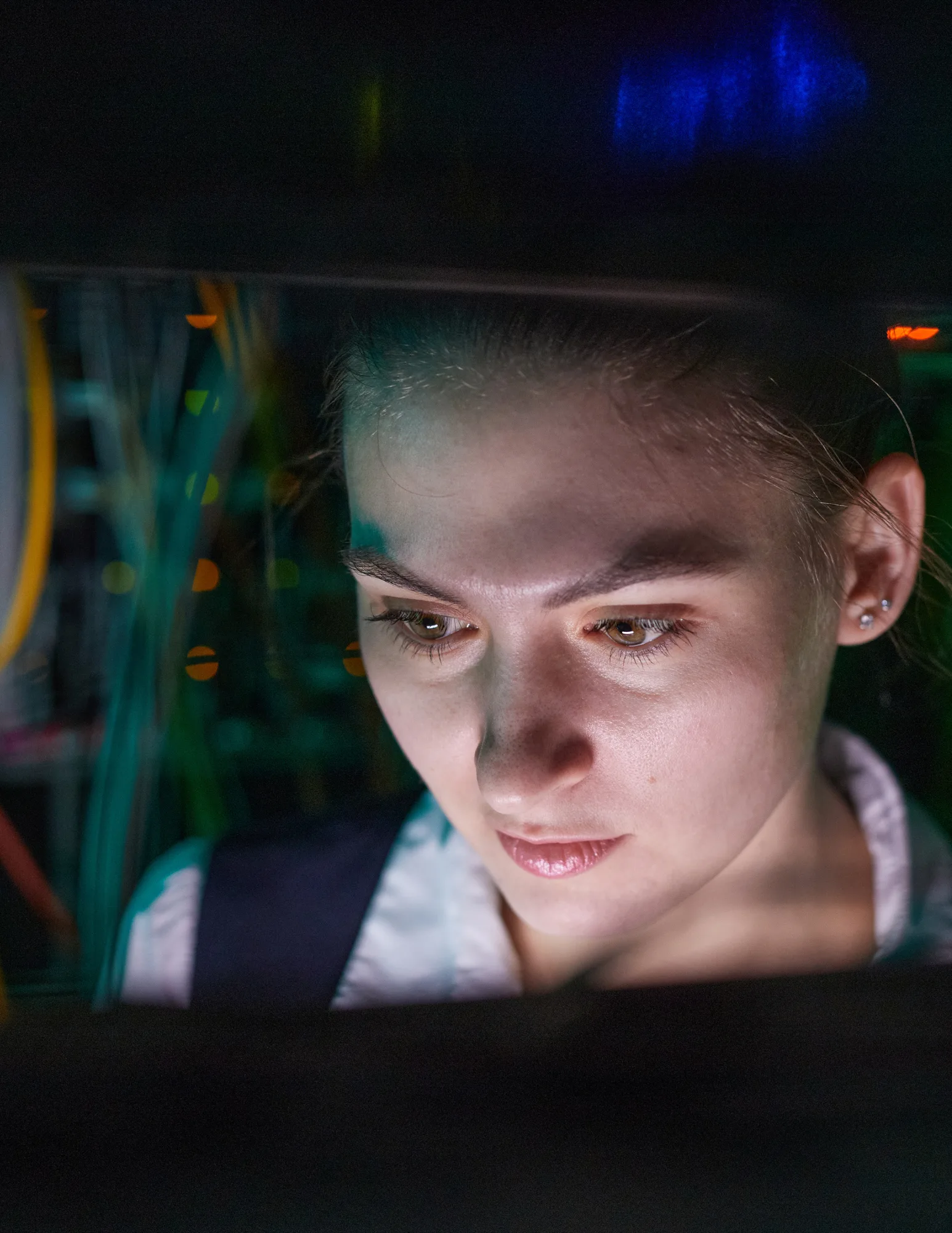 female network engineer locating cables inside of a server rack